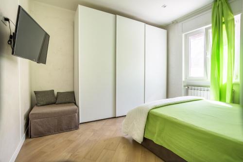 a bedroom with a bed and a chair and a television at RomaDamare in Passoscuro