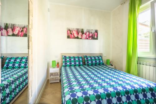 a bedroom with a bed and a window with green curtains at RomaDamare in Passoscuro