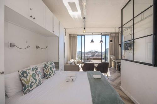 a bedroom with a large bed and a living room at Homely Studio Apartment in Cape Town in Cape Town