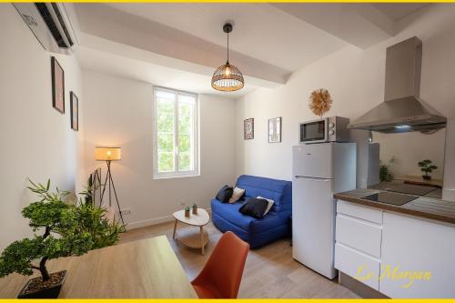 un salon avec un canapé bleu et une cuisine dans l'établissement Le Morgan - Magnifique appartement cours principal plein centre avec parking, à Salon-de-Provence
