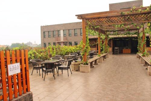 an outdoor patio with tables and chairs and a building at King Parkview Hotel in Beijing