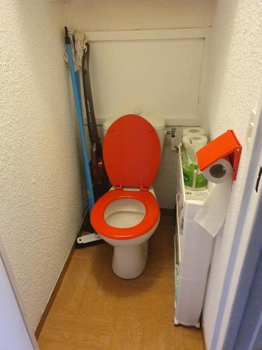 a bathroom with a red toilet in a room at studio 4 pers Puy-Saint-Vincent 1700 in Puy-Saint-Vincent