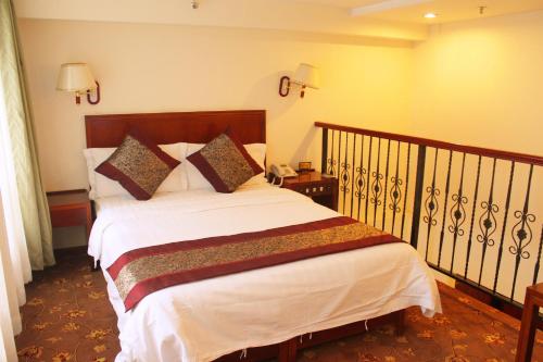 a bedroom with a bed with white sheets and pillows at King Parkview Hotel in Beijing