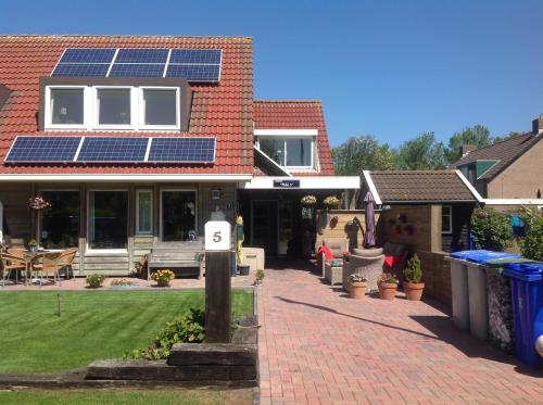 une maison avec des panneaux solaires sur le toit dans l'établissement Paal 5, à Hollum