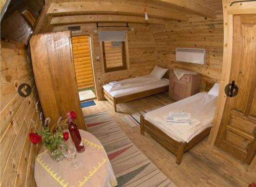 a room with two beds and a table in a cabin at Lolini bungalovi in Novi Sad