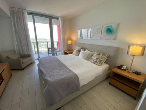 a bedroom with a large bed and a balcony at Elegant Miami Beach Apt Ocean Views, Full Kitchen & Style in Hallandale Beach
