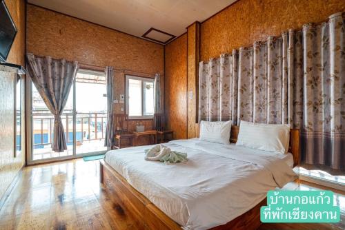 a bedroom with a bed and a large window at Baan Kokaew Chiang Khan in Chiang Khan