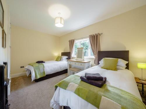 1 dormitorio con 2 camas y ventana en Renchers Farmhouse, en Crossway Green
