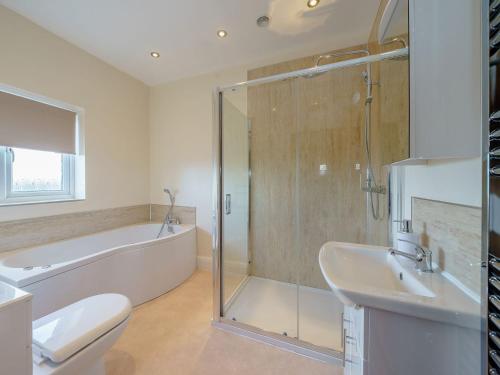 a bathroom with a tub and a toilet and a sink at Renchers Farmhouse in Crossway Green