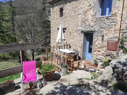 una mesa y sillas frente a un edificio de piedra en Domaine de Cruvelet Petit gite, en Trigance