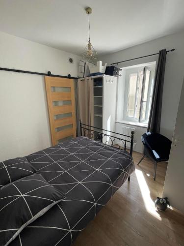 une chambre avec un lit et une chaise dedans dans l'établissement Le Petit Duc, à Dijon