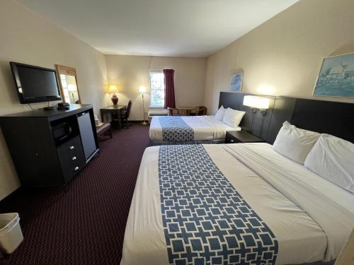 ein Hotelzimmer mit zwei Betten und einem Flachbildfernseher in der Unterkunft Olde Amish Inn in Ronks