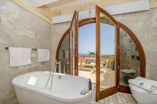 a bathroom with a tub and a shower and a toilet at The Almonds Luxury Villa in San Lawrenz