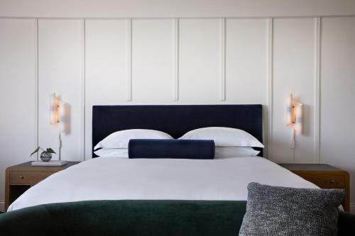 a bedroom with a large white bed with a blue headboard at Kimpton Alton Fisherman's Wharf by IHG in San Francisco