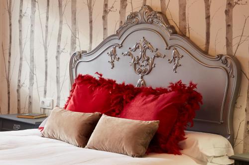 a bed with a large headboard with red pillows at Luxury Singular Villa Rosa in Padrón