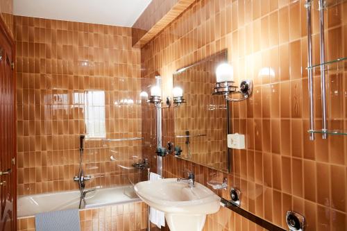 uma casa de banho com um lavatório, um chuveiro e um WC. em Luxury Singular Villa Rosa em Padrón