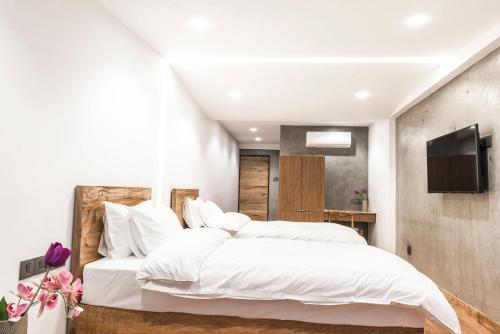 a bedroom with a large white bed and a television at 9ine Thamel Hotel in Kathmandu