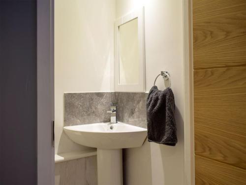 a bathroom with a white sink and a mirror at Windhover in Glasbury