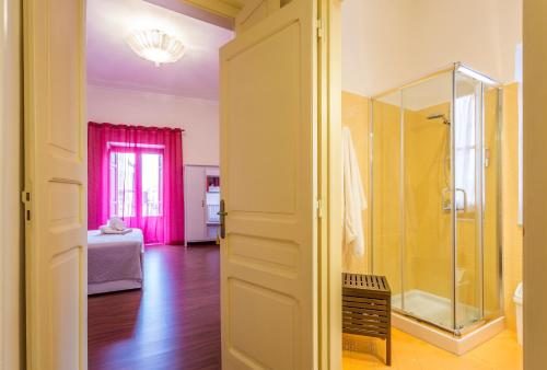 a bathroom with a glass shower and a bedroom at Case Spazioscena - Calliope in Castelbuono