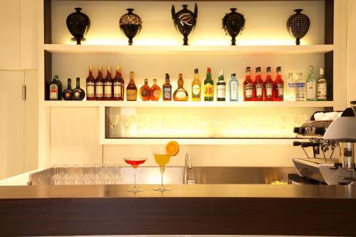 un bar con diverse bottiglie e bicchieri su uno scaffale di Hotel Palladio a Vicenza