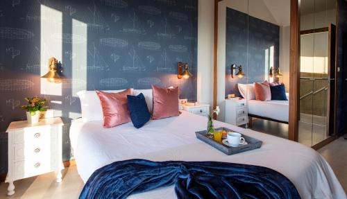een slaapkamer met een groot bed met rode en blauwe kussens bij Luxury Singular Villa Carolina in Corrubedo