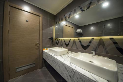 a bathroom with two sinks and a mirror at Hilly Hotel in Edirne