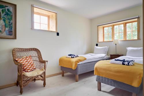 1 Schlafzimmer mit 2 Betten, einem Stuhl und einem Fenster in der Unterkunft Spectacular 6-bed house in beautiful manor park in Mariefred