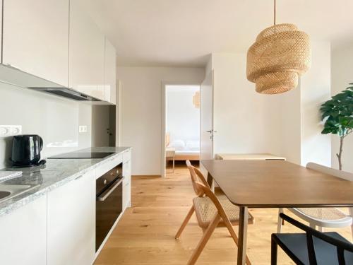 eine Küche und ein Esszimmer mit einem Holztisch in der Unterkunft STAD10 - Apartments very close to subway U2 Stadlau in Wien