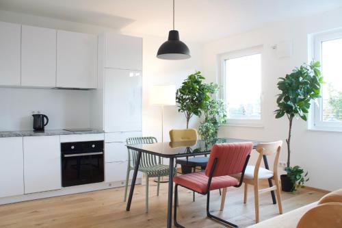 a kitchen and dining room with a table and chairs at STAD10 - Apartments very close to subway U2 Stadlau in Vienna