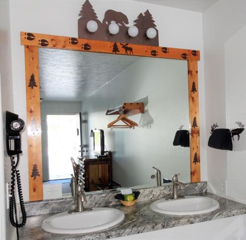 un espejo sobre dos lavabos en un baño en Eagle's Nest Motel en Priest River
