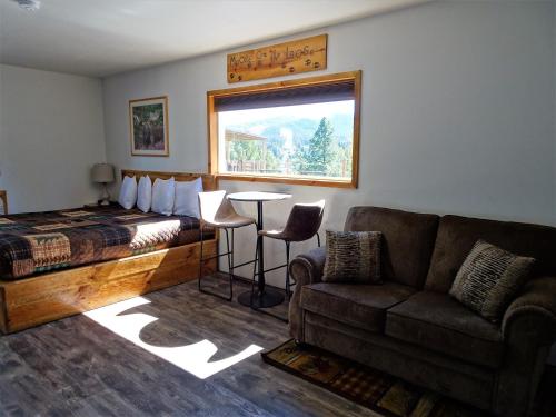 a living room with a couch and a bed and a window at Eagle's Nest Motel in Priest River