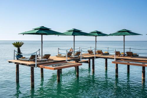 a pier with chairs and umbrellas on the water at Rixos Premium Belek - The Land of Legends Access in Belek