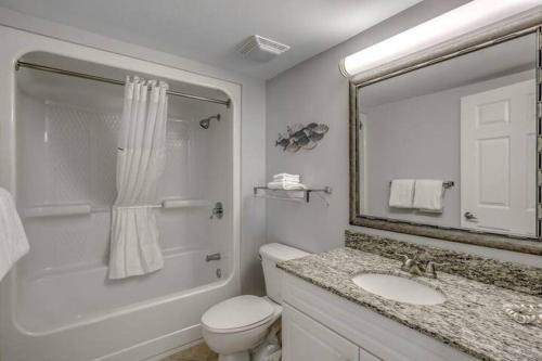 a bathroom with a toilet and a sink and a mirror at 2 Bedroom Condo Amazing Views - Updates Galore in Myrtle Beach