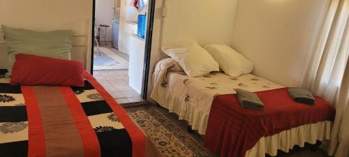 Habitación pequeña con 2 camas y espejo. en Vanross Self Catering Accommodation, en Thabazimbi
