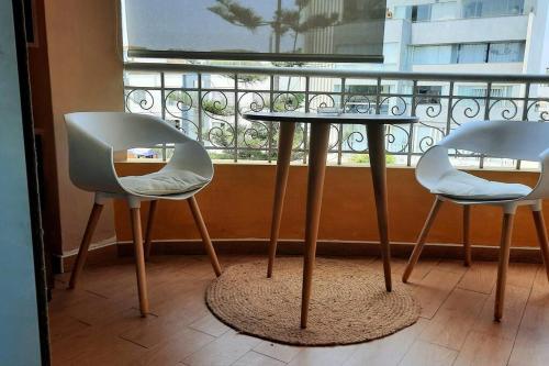 two chairs and a table in front of a window at Balconcito Peruano& Ciudad real 302 & 2 bedroom in Lima