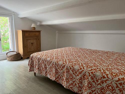a bedroom with a bed and a dresser and a window at Domaine du Cruvelet Grand gite in Trigance