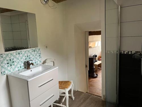 a white bathroom with a sink and a mirror at Domaine du Cruvelet Grand gite in Trigance