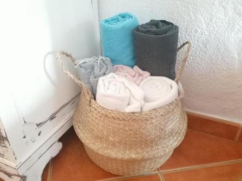 a basket of towels sitting next to a wall at A Casa Pequenina - Escusa, Marvão in Marvão