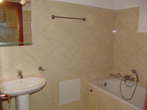un bagno con lavandino e vasca da bagno di Captain Homer Studios a Mesongi