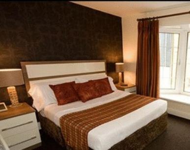 a bedroom with a large bed and a large window at The White Lady Hotel in Kinsale