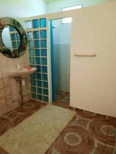a bathroom with a sink and a shower with a mirror at F3 paisible in Capesterre-Belle-Eau