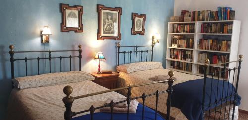 um quarto com duas camas e uma estante de livros com livros em El Molino de arriba em Níjar