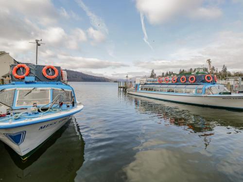 two boats are docked at a dock in the water at Newfield Apartment 1 in Broughton in Furness