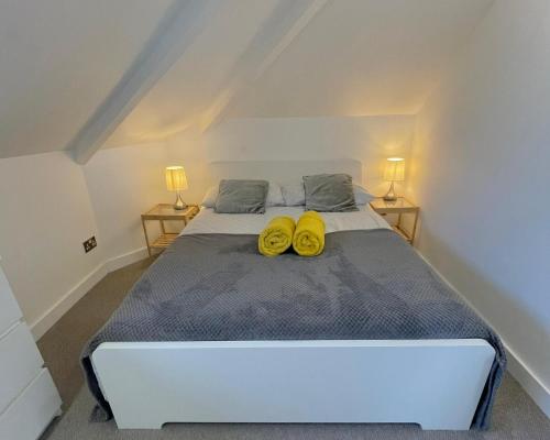 a bedroom with a bed with two yellow shoes on it at La Fontaine Court Apartments - Aldershot in Aldershot