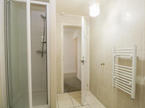 a bathroom with a shower and a glass shower door at Newfield Apartment 2 in Broughton in Furness