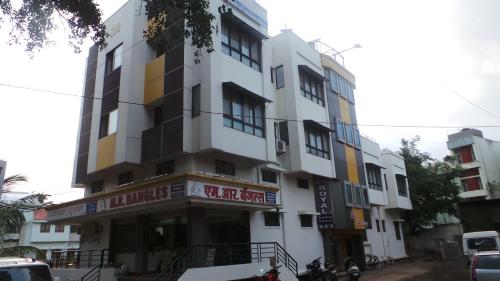 Ein hohes weißes Gebäude mit einem Schild drauf. in der Unterkunft Hotel Royal Residency Executive in Miraj