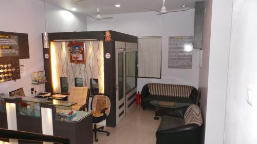 a waiting room with a couch and a table and chairs at Hotel Royal Residency Executive in Miraj