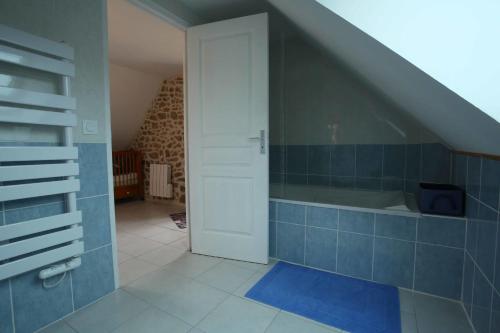 a bathroom with a blue tiled floor and a white door at Ferme Cidricole Hugues Desfrièches in Sainte-Marguerite-de-Carrouges