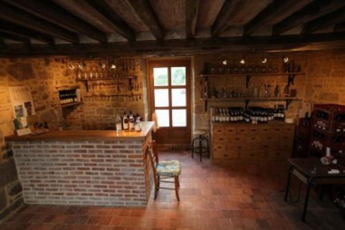 - une cuisine avec un bar dans une pièce dotée d'un mur en briques dans l'établissement Ferme Cidricole Hugues Desfrièches, à Sainte-Marguerite-de-Carrouges