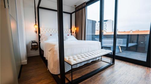 1 dormitorio con cama blanca y ventana grande en Hills Hotel Lisboa, en Lisboa